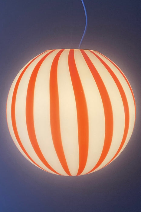 Ny Murano candy pendel loftlampe i en bolsje kombination af rød og hvid. Mundblæst glas i rund form med vertikale striber. E27 fatning. Kommer med justerbart messingbelagt ophæng samt transparent ledning.  Håndlavet i Italien.  D:40 cm 