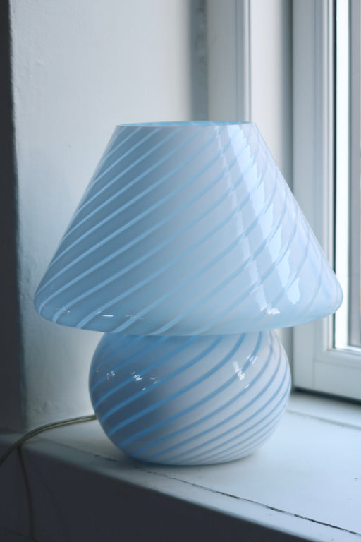 Vintage Murano mushroom lampe i mellem størrelse i nuancer af blå. Lampen er mundblæst i ét stykke glas med swirl og giver et virkelig hyggeligt lys. Håndlavet i Italien, 1970erne. ⁠⁠H:25,5 cm D:25 cm