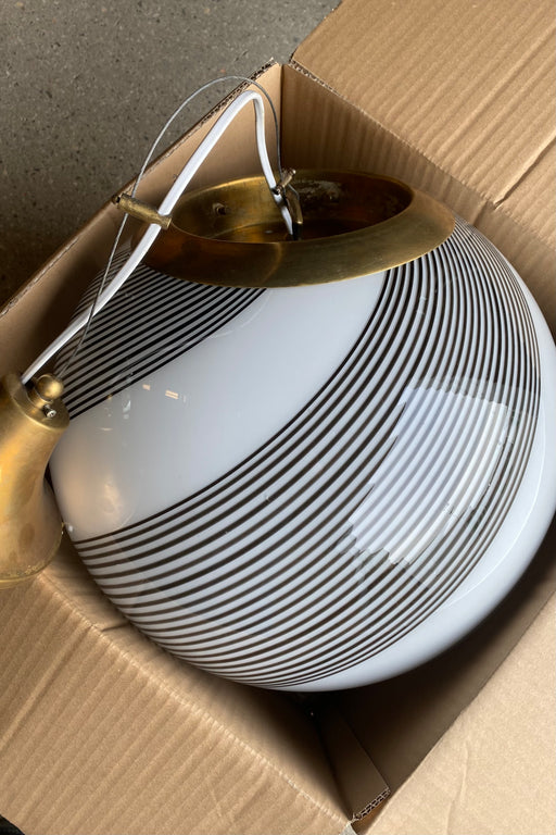 Stor vintage Murano pendel loftlampe i glas. Glasset er mundblæst i cirkulær form med et smukt swirl mønster. Håndlavet i Italien, 1970erne, og kommer med originalt justerbart ophæng i patineret messing.  D:40 cm 