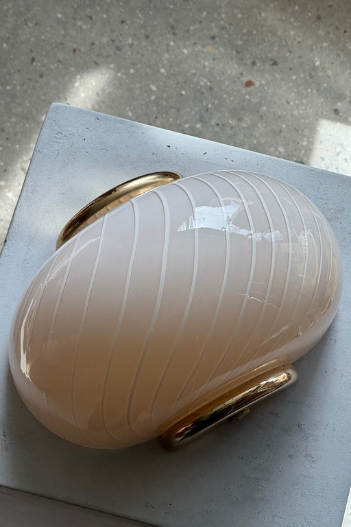 Vintage Murano creme væglampe med hvid swirl mønster og beslag i messing. Perfekt størrelse til din entré, i køkkenet, på badeværelset eller som læselamper i soveværelset. Super nemme at montere. Mundblæst i Italien, 1960/70erne og varierer i udtrykket.  Størrelse 22x15 cm. 