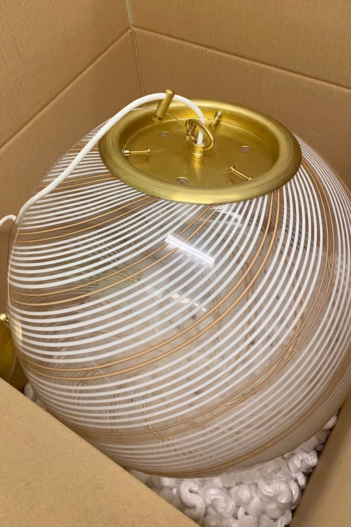Stor vintage Murano filigrana pendel loftlampe. Glasset er mundblæst i rund form med et smukt swirl mønster. Ses meget sjældent med orange tone i glasset. Håndlavet i Italien, 1970erne, og kommer med justerbart messing ophæng. D:40 cm