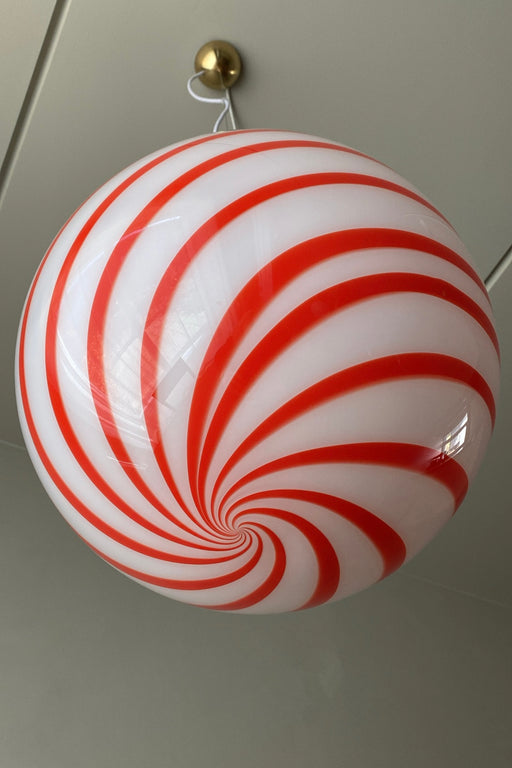 Ny Murano candy pendel loftlampe i en bolsje kombination af rød og hvid. Mundblæst glas i rund form med swirl mønster. E27 fatning. Kommer med justerbart messingbelagt ophæng samt transparent ledning.  Håndlavet i Italien.  D:40 cm  