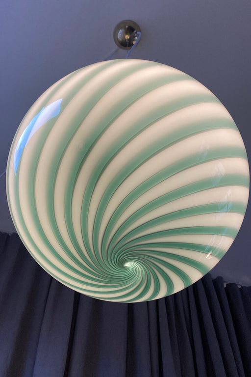 Italiensk Murano candy pendel loftlampe i grønt glas med swirl mønster.   Glasset er mundblæst hos en italiensk glaspuster familie, som arbejder i eget værksted. Udarbejdet efter traditionsrige Murano glaspuster teknikker. D:30 cm   Størrelsen er perfekt over et spisebord eller midt i en s