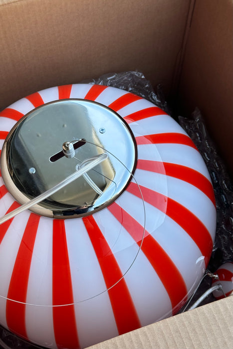 Ny Murano candy pendel loftlampe i en bolsje kombination af rød og hvid. Mundblæst glas i rund form med vertikale striber. E27 fatning. Kommer med justerbart messingbelagt ophæng samt transparent ledning.   Håndlavet i Italien. 