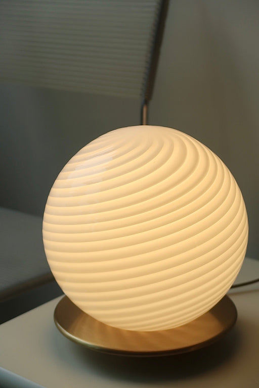 <span data-mce-fragment="1">Vintage Murano væglampe / bordlampe i&nbsp;hvid glas med swirl og messing bund. Lampen afgiver et meget hyggeligt lys og har en fantastisk swirl. Håndlavet i Italien, 1970erne, og har original Murano Vetri label.&nbsp;&nbsp;<br></span><span data-mce-fragment="1">H:22 cm D:20 cm</span>