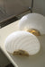 Smuk, klassisk vintage Murano væglampe i hvid glas med swirl mønster og beslag i messing. Perfekt størrelse til din entré, i køkkenet, på badeværelset eller som læselampe i soveværelset. Super nemme at montere. Lamperne stammer fra et kloster i Italien, som skulle ombygges og renoveres og har derfor alderssvarende patina på beslag. Mundblæst i Italien, 1960/70erne og varierer i udtrykket. Størrelse 22x15 cm. 