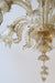 Smuk vintage Murano lysekrone.   Lysekronen er udformet i mundblæst golden glas og består af 6 arme med hver sin lyskilde. Utrolig detaljerig med mundblæste blomster og blade. Teknikkerne benyttet ses oftest hos fra Venini, Barovier & Toso samt Archimede Seguso. Den har 6 x E14 fatning og giver masser af lys (pærer medfølger ikke). Håndlavet i Italien, 1960/70erne. En enkelt blomst har afslag og samme gælder nedre prisme. Det ses dog ikke på afstand og er typisk for de vintage lysekroner. 
