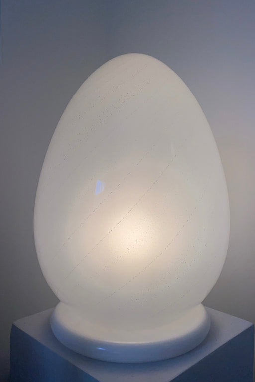 Stor vintage Murano bordlampe i glas med sølv swirl. Mundblæst i en smuk oval form som et æg og er derfor kendt som ''egg lamp''. Håndlavet i italien, 1970erne, og kommer med ny hvid ledning.