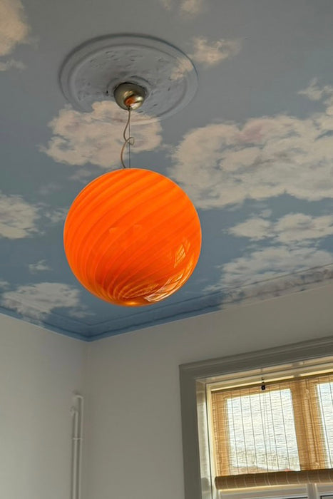 Italiensk Murano candy pendel loftlampe i brændt orange / rav glas med swirl mønster.   Glasset er mundblæst hos en italiensk glaspuster familie, som arbejder i eget værksted. Udarbejdet efter traditionsrige Murano glaspuster teknikker. D:40 cm   Størrelsen er perfekt som spisebordslampe eller midt i en stue. 
