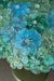Stor vintage Murano bordlampe udformet med talrige mundblæste glasblomster i nuancer og af blå og grøn. Står solid på fod i patineret metal/messing. 2x E14 lyskilder. Håndlavet i Italien, 1970/80erne. 