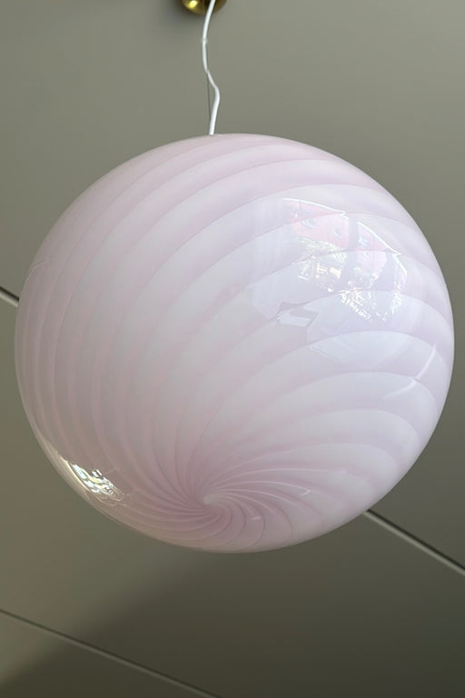 Ny Murano candy pendel loftlampe i en fin blød lyserød nuance. Mundblæst glas i oval form med swirl mønster. E27 fatning. Kommer med justerbart messingbelagt ophæng samt transparent ledning.  Håndlavet i Italien.  D:40 cm  