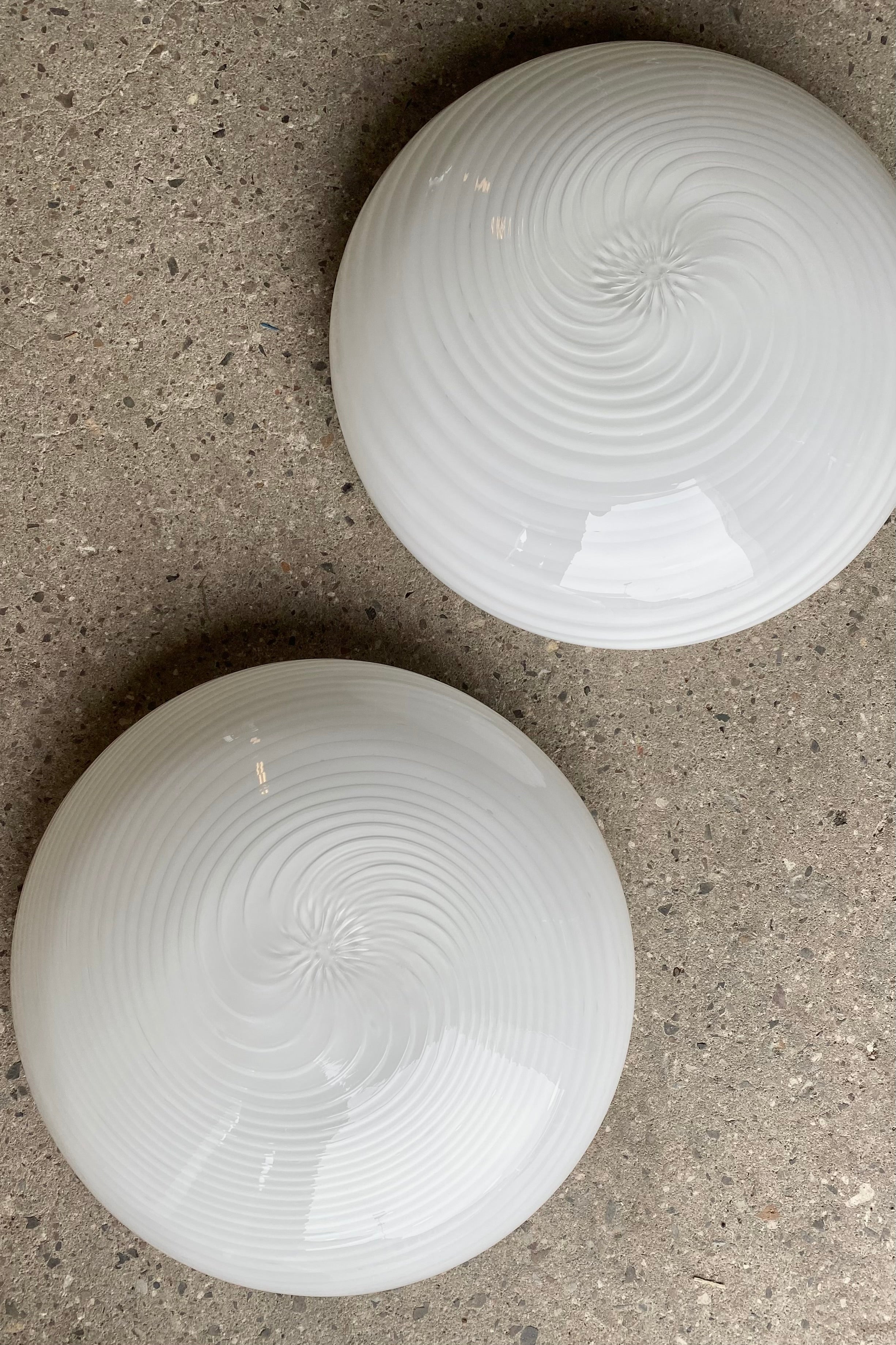 Sæt á 2 stk vintage Murano plafond loftlamper / væglamper. Mundblæst hvid opal glas med swirl. E27 fatninger. Håndlavet i Italien, 1970erne. Begge med originale labels.<br>D:38 cm⁠⁠ H:14 cm