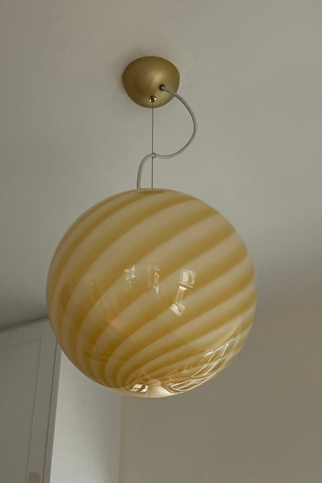 Stor ny italiensk Murano candy pendel loftlampe i en smuk blød gul nuance. Mundblæst glas i rund form med swirl mønster. E27 fatning. Kommer med justerbart messingbelagt ophæng samt transparent ledning. 