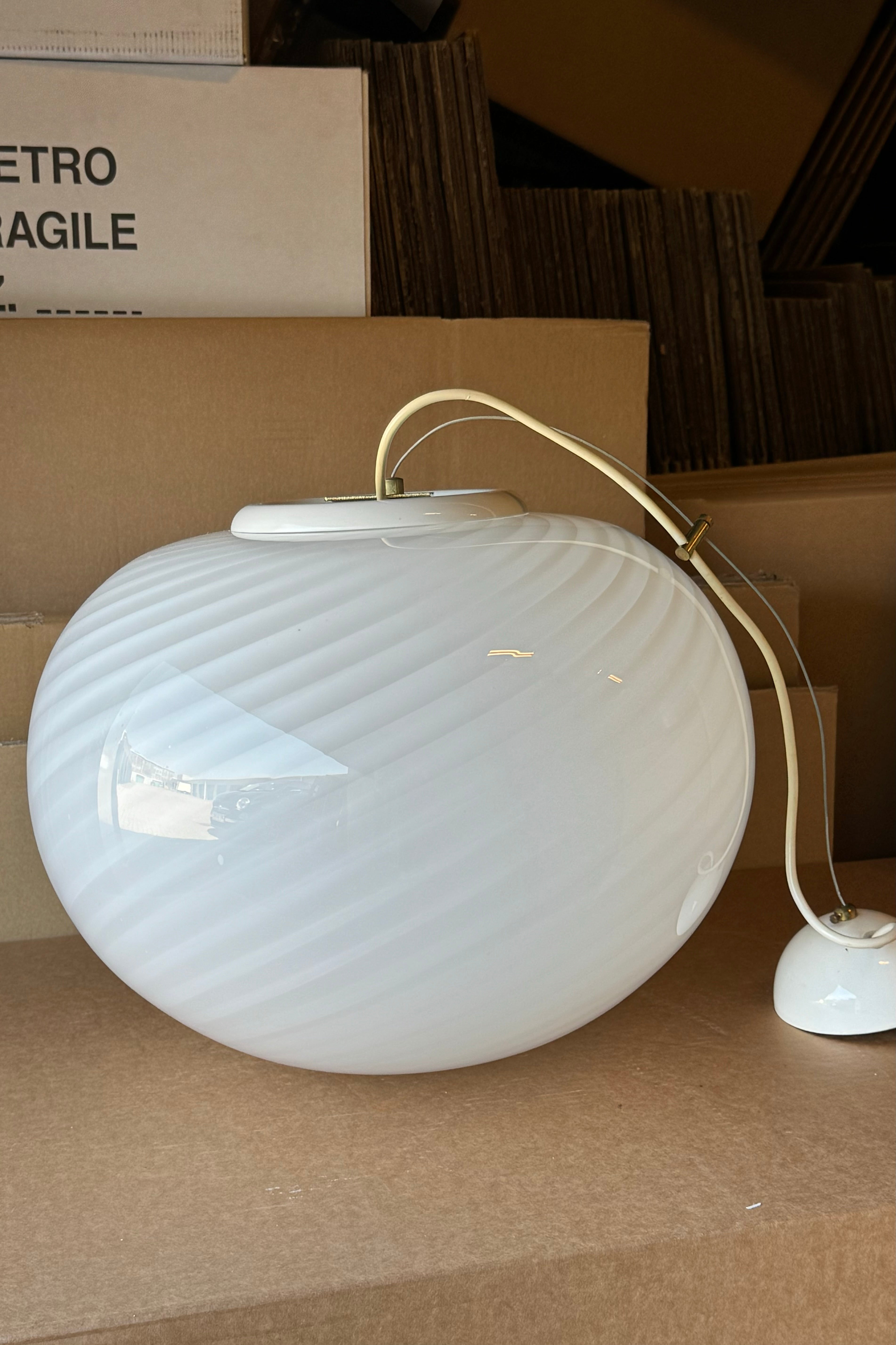 Stor vintage Murano pendel loftlampe i hvid opaline glas. Glasset er mundblæst i oval form med et smukt swirl mønster. Håndlavet i Italien, 1970erne, og kommer med originalt justerbart ophæng. Bemærk små mørke prikker i glasset fra den blev mundblæst.  D:40 cm 