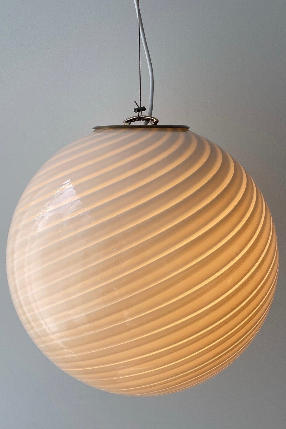 Vintage Murano pendel loftlampe i creme glas. Glasset er mundblæst i cirkulær form med et smukt hvidt swirl mønster. Justerbart messing ophæng. Håndlavet i Italien, 1970erne.