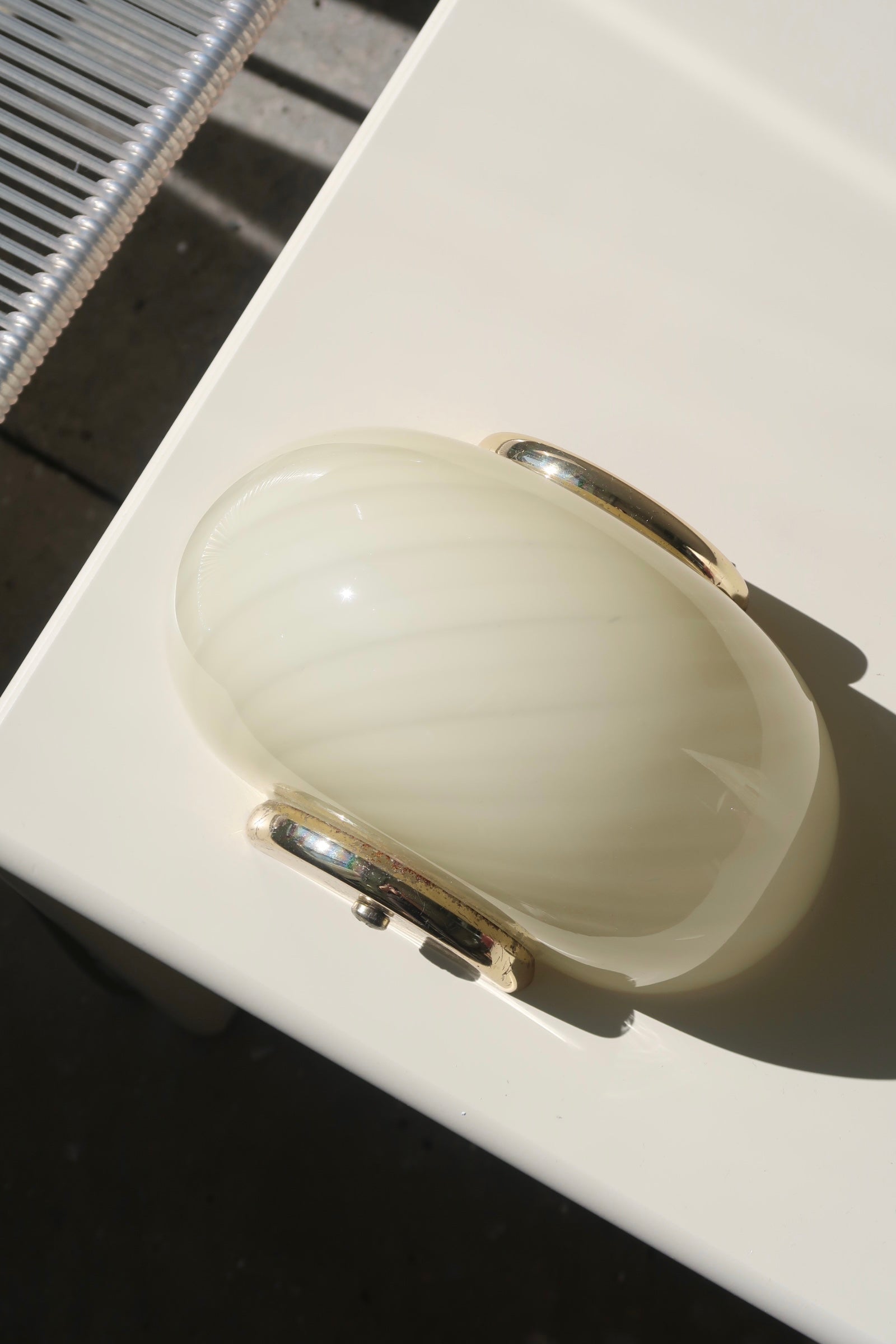 Smuk vintage Murano væglampe i creme gul glas med swirl mønster. Mundblæst i Italien, 1970erne, og kommer med messing beslag. Perfekt størrelse til din entré, i køkkenet, på badeværelset eller som læselampe i soveværelset. Meget lette at montere. Størrelse 22x15 cm. 
