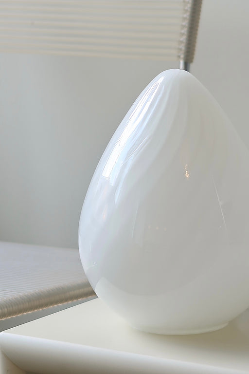 Vintage Murano egg lampe i hvid glas med swirl. Mundblæst i en smuk oval form som et æg og er derfor kendt som ''egg lamp''. Helt fantastisk, skulpturel lampe. Håndlavet i Italien, 1960/70erne. Kommer med ny hvid ledning. ⁠H: 21 cm D: 14 cm