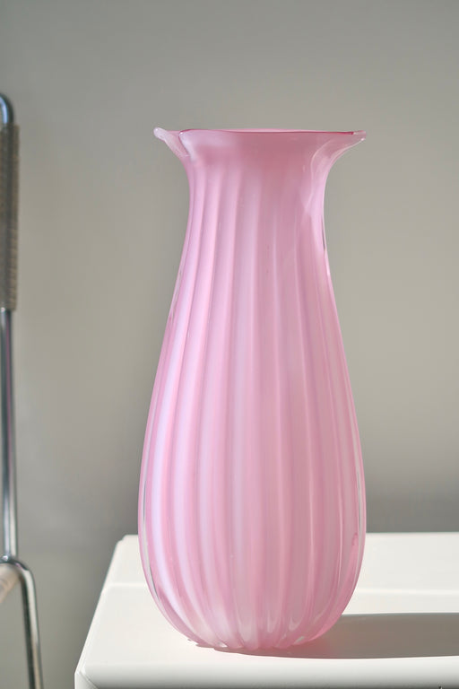 Stor vintage Murano glasvase. Vasen er mundblæst i lyserød / pink alabastro glas, som har en helt særlig dybde i dagslys. Denne glastype er blevet et samleobjekt grundet sjældenhed og den helt fantastiske nuance. Håndlavet i Italien, 1950/60erne, og har originalt Murano klistermærke. H:30 cm L:13 cm B:10 cm 