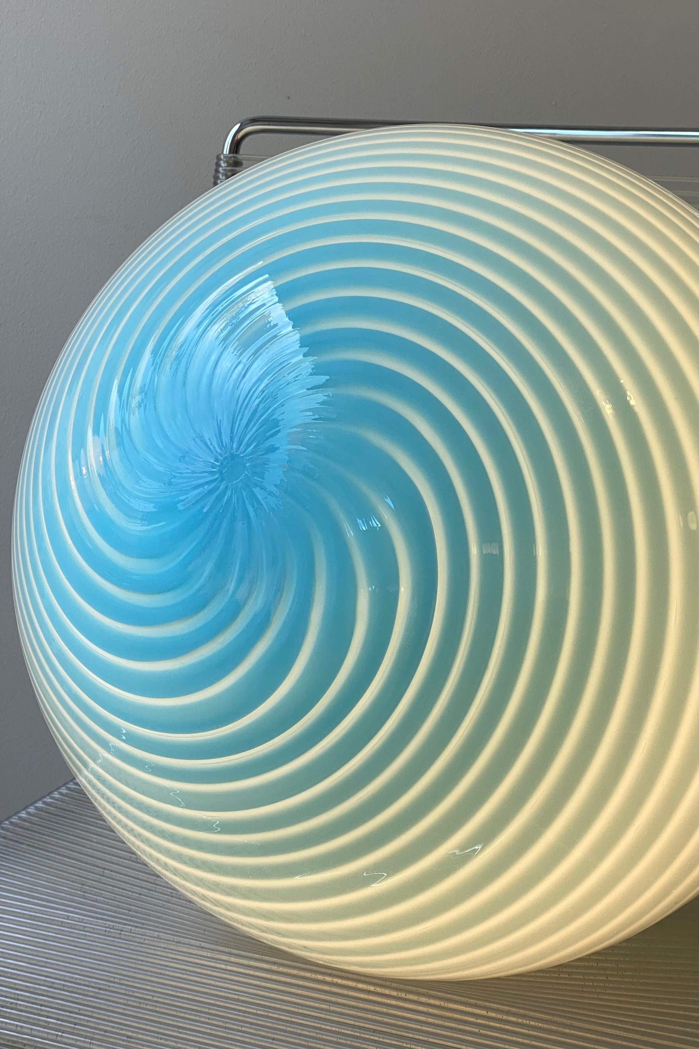 Stor vintage Murano Vetri loftlampe i lyseblå glas. Glasset er mundblæst i rund form med et smukt swirl mønster. Håndlavet i Italien, 1970erne, og har original Murano Vetri mærkat samt messing ophæng. D:40 cm 