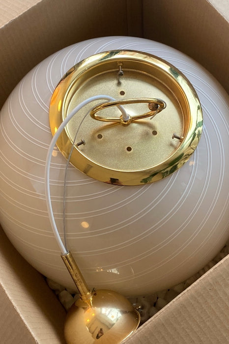 Vintage Murano pendel loftlampe i creme glas. Glasset er mundblæst i cirkulær form med et smukt hvidt swirl mønster. Messing ophæng. Håndlavet i Italien, 1970erne.  D:40 cm 