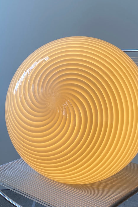 Stor vintage Murano Vetri loftlampe i gult glas. Glasset er mundblæst i oval form med et smukt swirl mønster. Håndlavet i Italien, 1970erne, og har original Murano Vetri mærkat samt messing ophæng. D:45 cm H:32 cm (glas) murano ceiling lamp globe pendant
