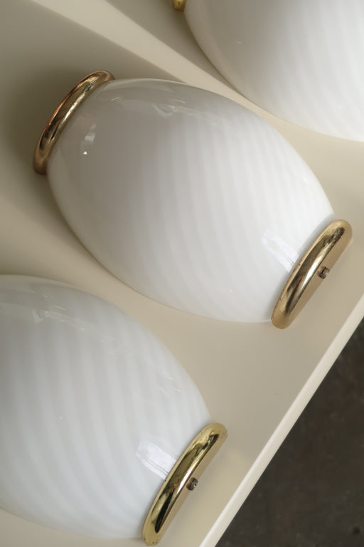 Smuk vintage Murano væglampe i opal hvid med swirl mønster i glasset. Mundblæst i Italien, 1970erne, og har messing beslag. Perfekt størrelse til din entré, i køkkenet, på badeværelset eller som læselampe i soveværelset. Meget lette at montere. Størrelse H:23 cm B:15 cm D:7 cm 