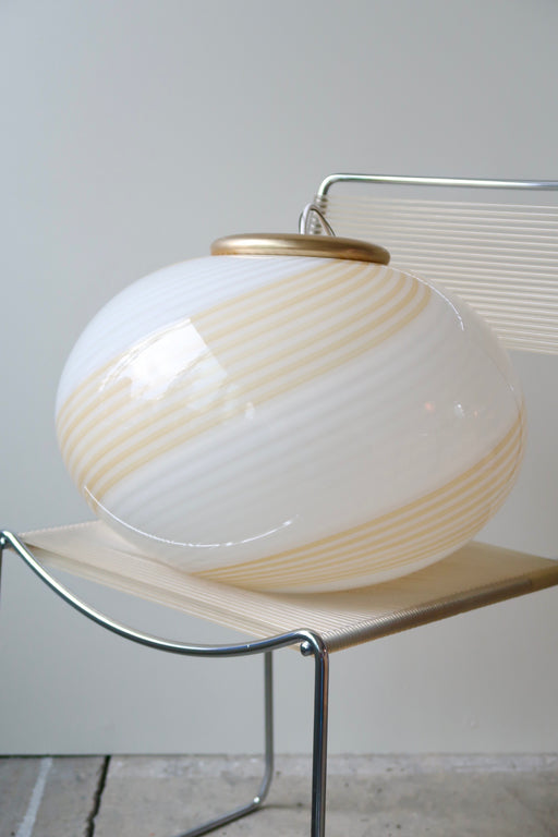 Smuk vintage Murano loftlampe i glas med messing ophæng. Glasset er mundblæst i oval form med hvid og gul swirl mønster. Håndlavet i Italien, 1970erne, og kommer med ny hvid ledning. Har originalt Murano label. D:45 cm  