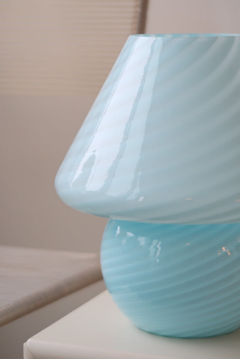 Vintage Murano mushroom lampe i mellem størrelse i den fineste, klare blå nuance. Lampen er mundblæst i ét stykke glas med swirl og giver et virkelig hyggeligt lys. Håndlavet i Italien, 1970erne, og har fået ny hvid ledning. Lampen har originalt Murano Vetri klistermærke. ⁠⁠H:27 cm