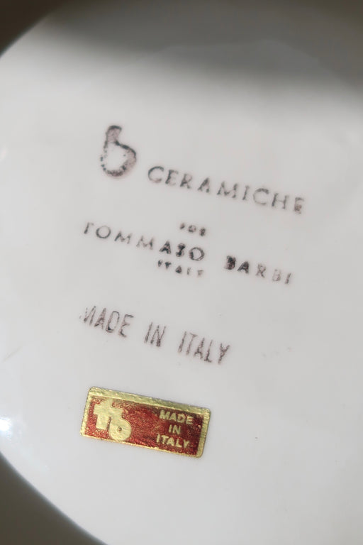 Original vintage Tommaso Barbi skål i riflet sandfarvet keramik med messing indsats. Skålen er håndlavet i Italien, 1970erne, og signeret i bunden. Tommaso Barbi er en anerkendt italiensk designer, som særligt i 1970erne udformede finurlige og fantasirige lamper samt møbler. D: 25 cm. H: 6,5 cm. 