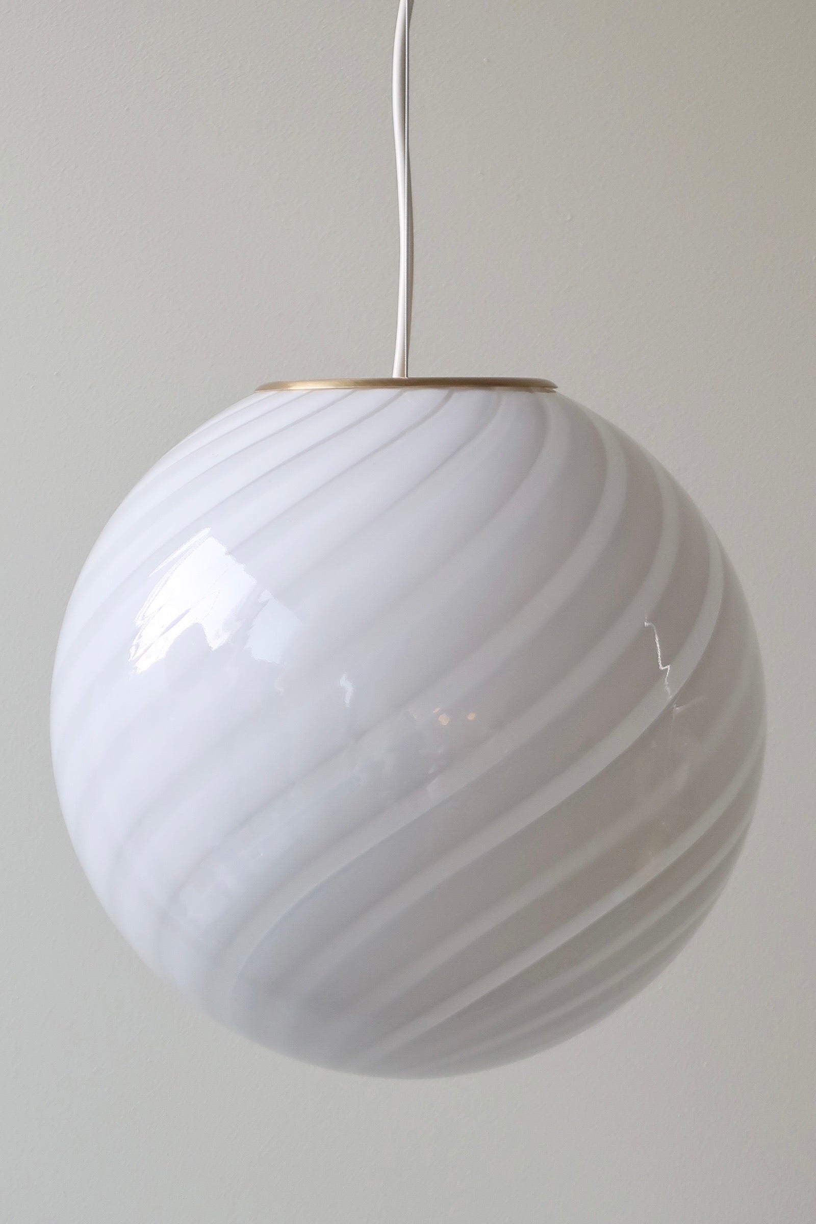 Smuk ny italiensk mundblæst pendel loftlampe. Mundblæst i lys grå glas med swirl mønster efter traditionsrige Murano glaspuster teknikker. Kommer med nyt håndlavet messing ophæng og hvid ledning. D:30 cm   I og med det er mundblæst glas, kan swirl afvige en smule fra glas til glas og der kan være små magiske bobler og andre unikke kendetegn.   