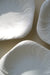 Original vintage Royal Copenhagen Konkylie frokosttallerken i den smukke hvide glasur. Stellet er designet af den anerkendte danske juveler og guldsmed Arje Griegst i 1978 og produceres ikke længere. Arje Griegst er desuden verdenskendt for sine smykker, skulpturer og glas. Hans arbejde inkluderer værker for Holmegaard og Georg Jensen.