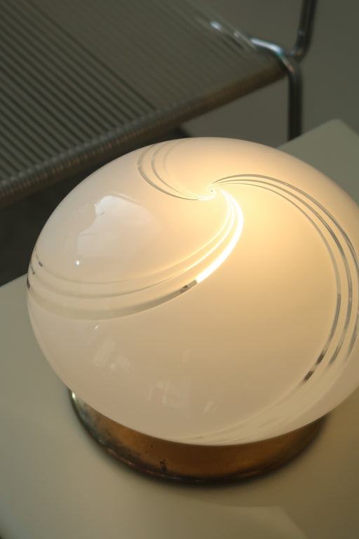 Vintage Murano bordlampe i hvid glas med swirl og messing bund. Lampen afgiver et meget hyggeligt lys og har swirl. Håndlavet i Italien, 1970erne. D:23 cm H:16 cm 