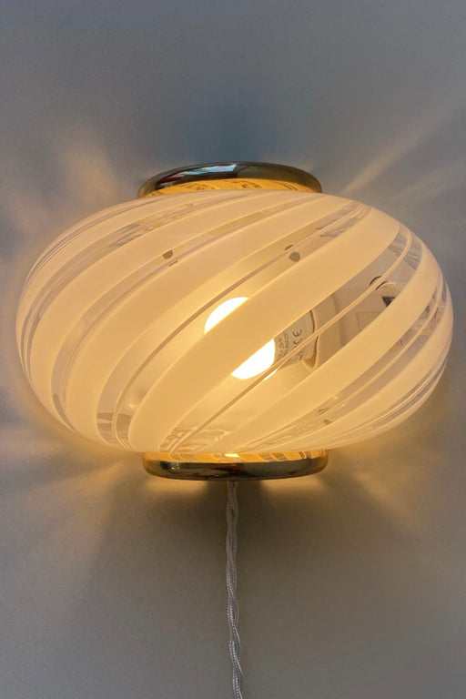 Vintage Murano væglampe i hvid glas med swirl mønster og beslag i messing. Perfekt størrelse til din entré, stue eller soveværelse. Super nemme at montere. Mundblæst i Italien, 1960/70erne. Størrelse 22x15 cm. 