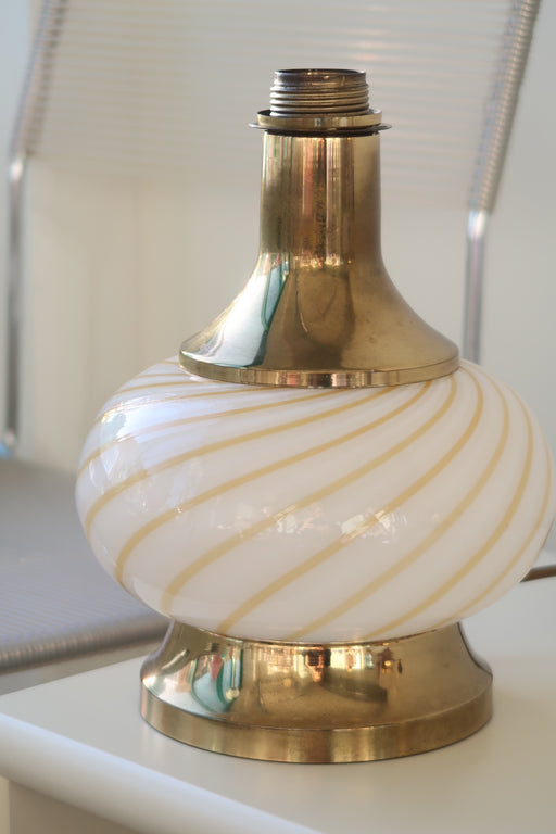 Vintage Murano lampefod i glas med hvid og gul swirl og messing detaljer. Mundblæst i rund form og har dobbelt fatning - dvs. den lyser både i glasbunden og i toppen. Lampen afgiver et meget hyggeligt lys og har en fantastisk swirl. Håndlavet i Italien, 1970erne. H:28 cm D:20 cm 